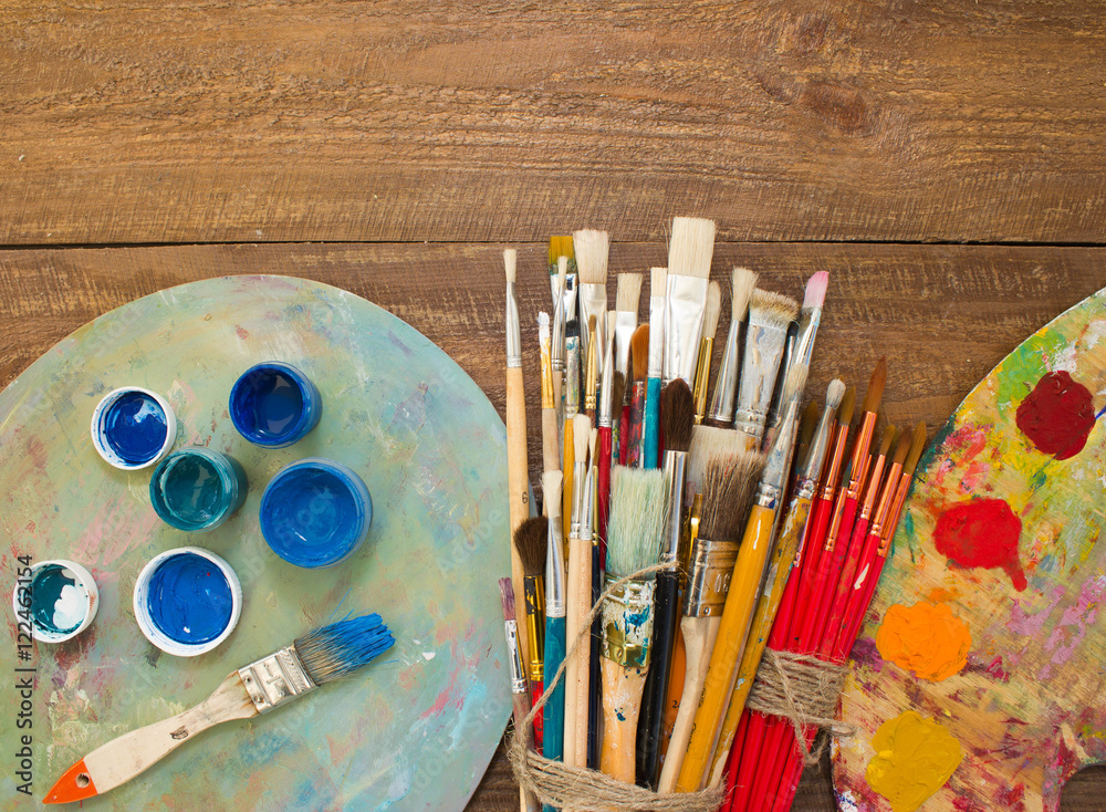 Fototapeta premium Paints, brushes and palette on the colorful background. The workplace of the artist. Banner for school