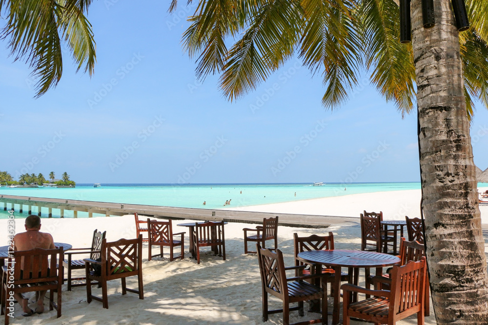 romantic outdoor restaurant table and chairs at the beach on sun