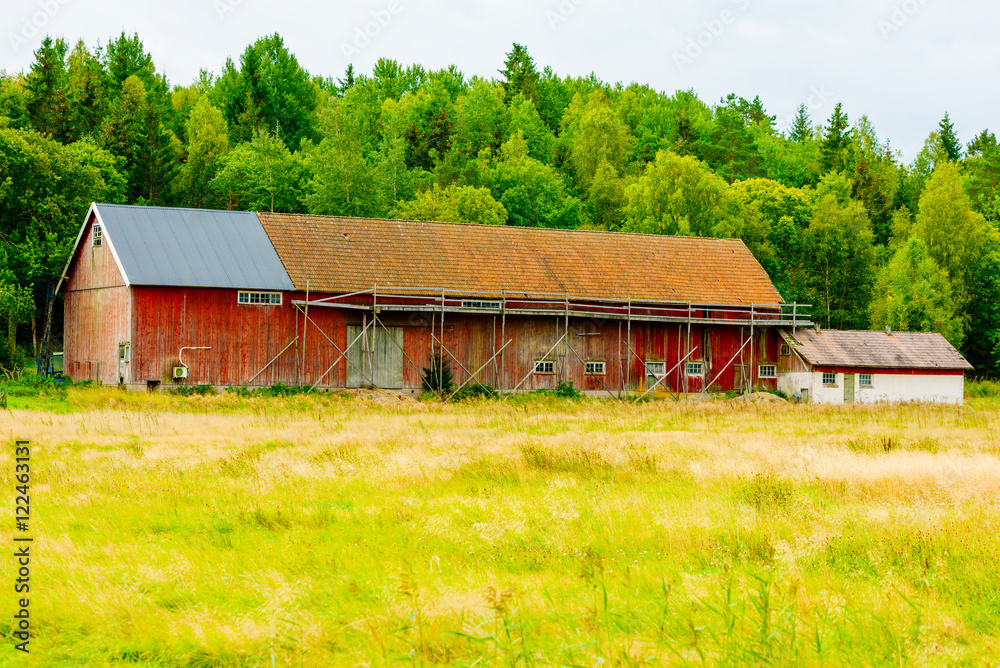 Old barn or farmhouse with makeshift wooden scaffolds outside. Old barn or farmhouse with makeshift wooden scaffolds outside.