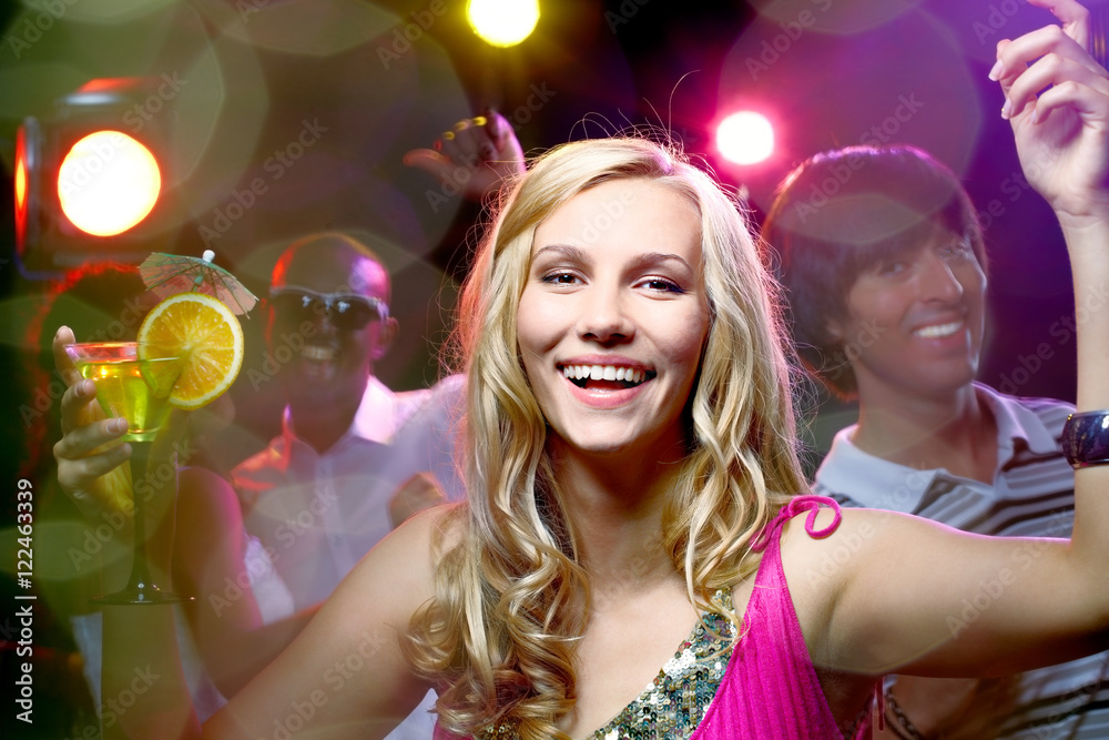 Portrait of a beautiful blonde girl in nightclub looking at camera and smiling Portrait of a beautiful blonde girl in nightclub looking at camera and smiling