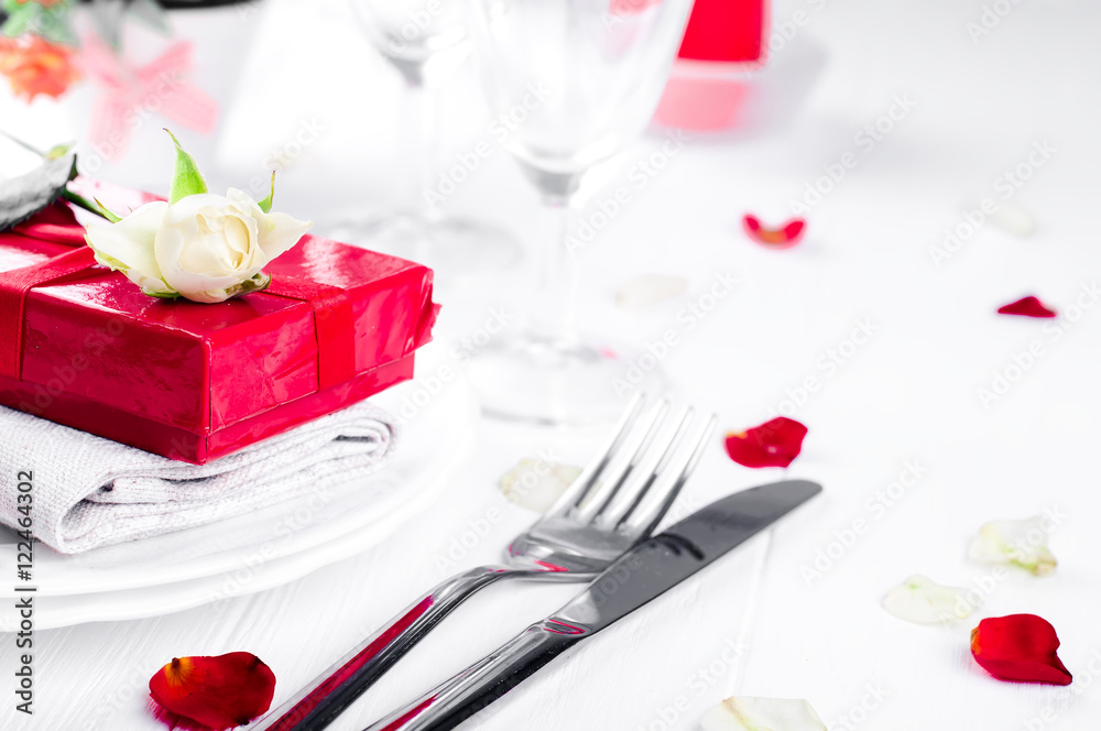 Elegant holiday table setting with red ribbon gift Elegant holiday table setting with red ribbon gift