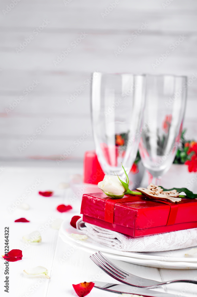 Elegant holiday table setting with red ribbon gift Elegant holiday table setting with red ribbon gift