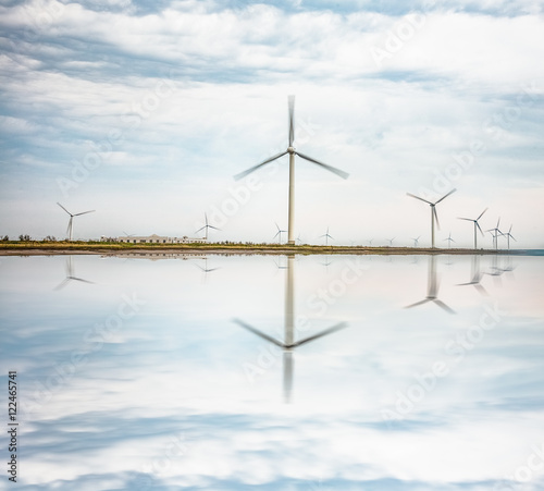 wind turbine farm and cloudy sky reflection,china. © kalafoto