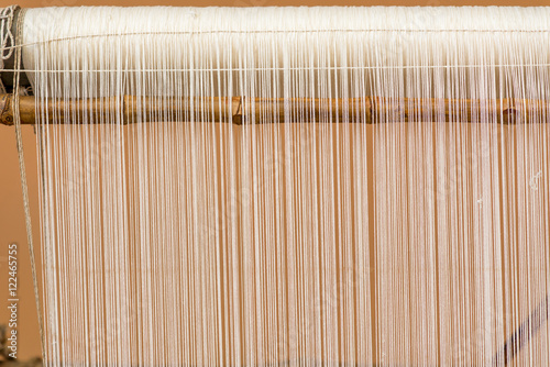 Bild auf Leinwand Close-up detail of a wooden handloom with white yarn, India
