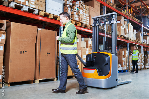 Warehouse Management System. Workers with barcode scanner and stacker