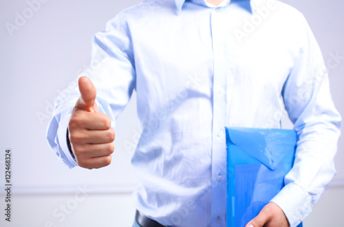 businessman with papers holds out his hand for a handshake