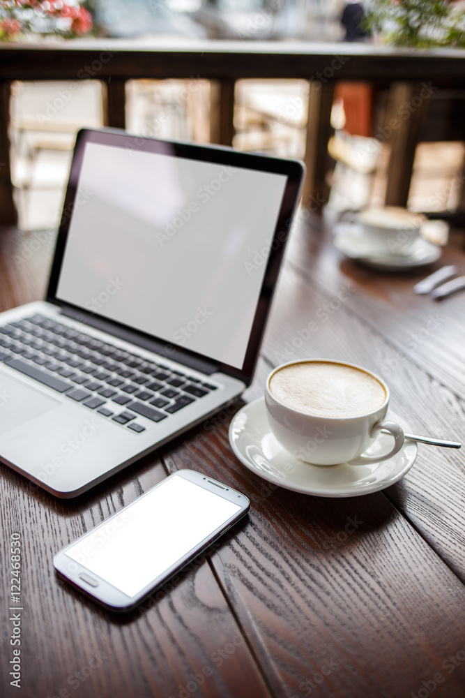 Fototapeta premium Mockup with laptop and smartphone on table in cafe