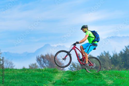 A young male riding a mountain bike outdoor .with soaring