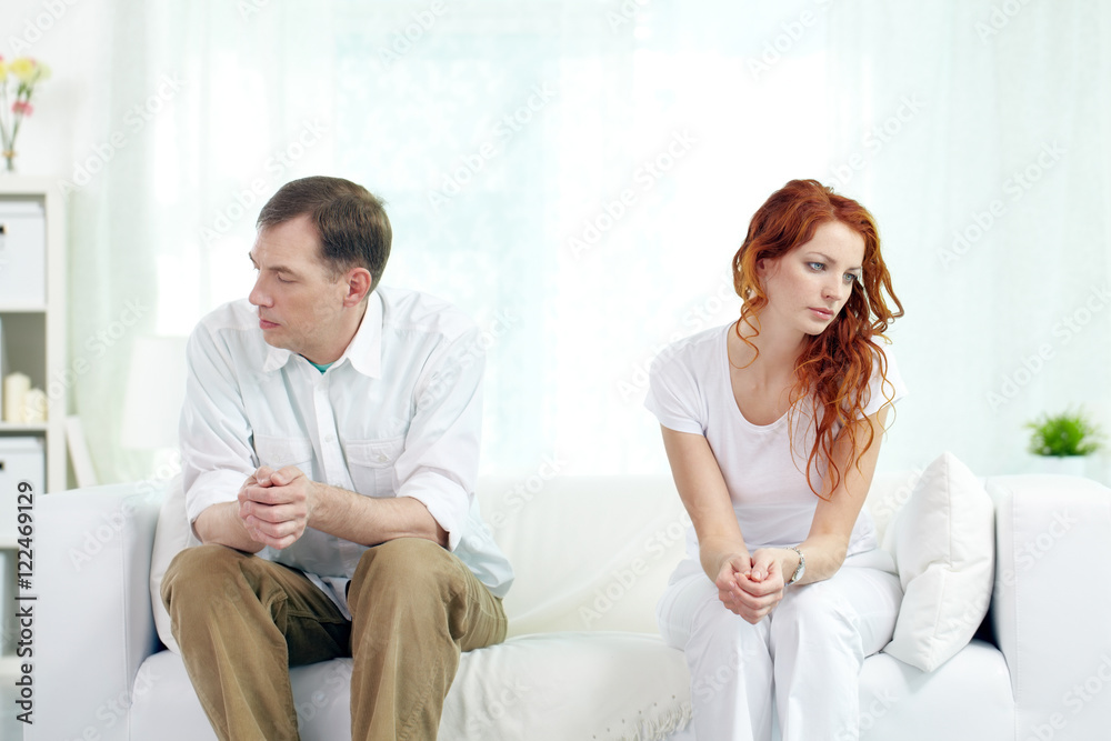 Obraz premium Young couple with relationship difficulties sitting on sofa at home