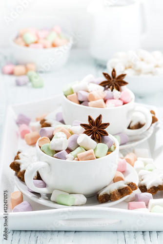 cocoa with colorful marshmallows and spices in white cups