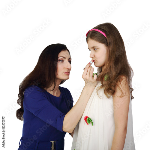 Woman paints girl lips with lipstick