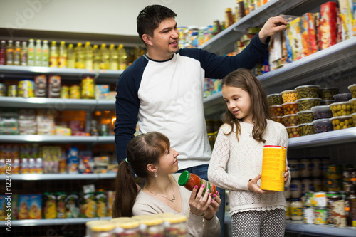 Happy family of three buying canned food