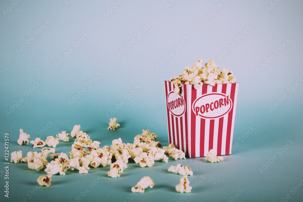 Popcorn bucket against a blue background Vintage Retro Filter.