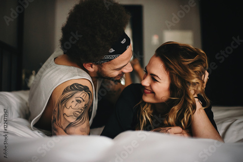 Happy young couple lying on bed photo