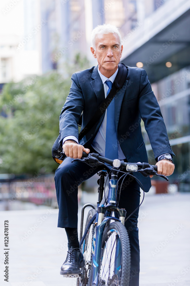 Successful businessman riding bicycle Successful businessman riding bicycle
