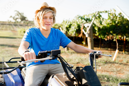 Boy riding farm truck in vineyard