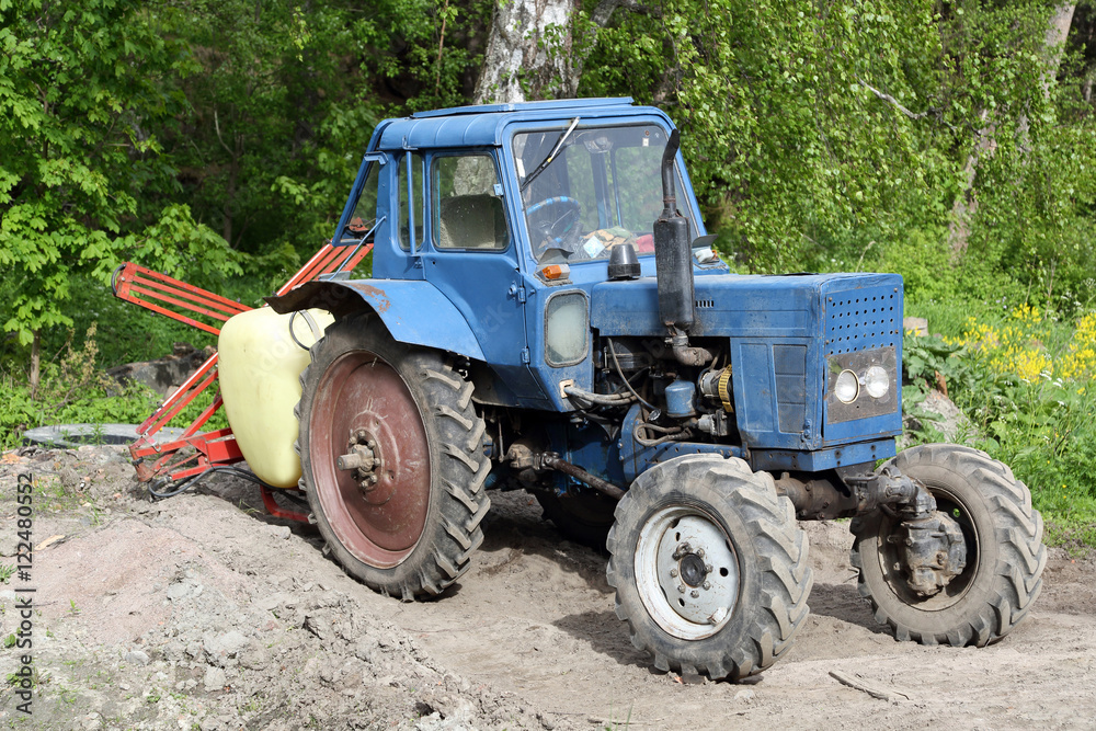 Fototapeta premium Old blue tractor on natural background outdoor