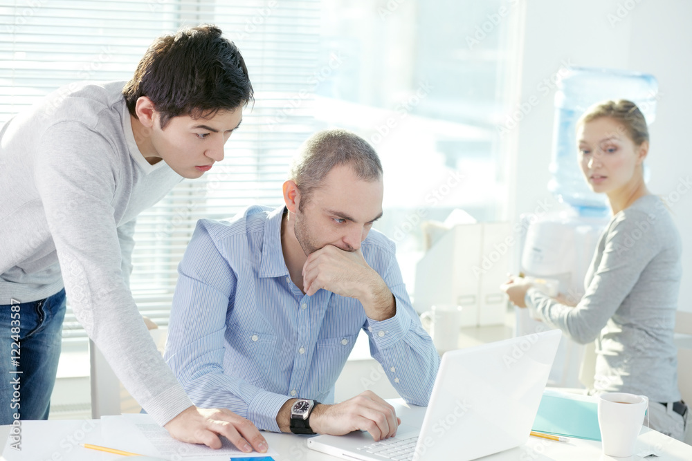 Two businessmen corresponding with their colleagues through internet and receiving puzzling e-mail Two businessmen corresponding with their colleagues through internet and receiving puzzling e-mail