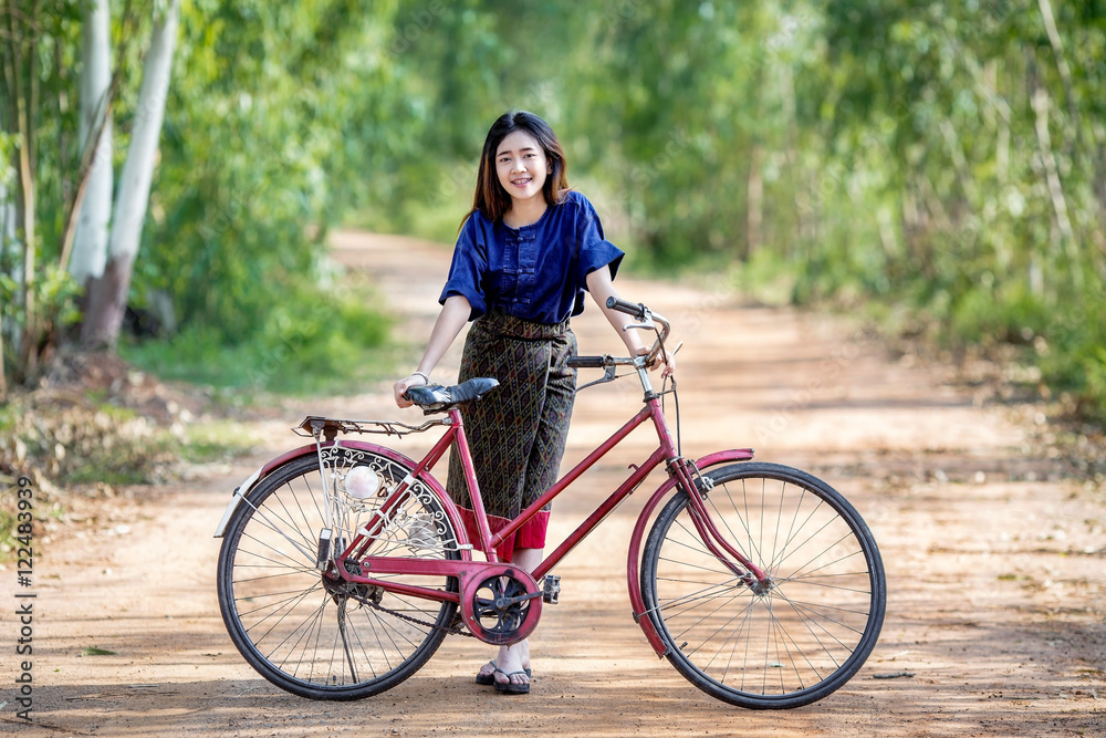 Asian farmer girl dressed in traditional local and her bicycle. Asian farmer girl dressed in traditional local and her bicycle.