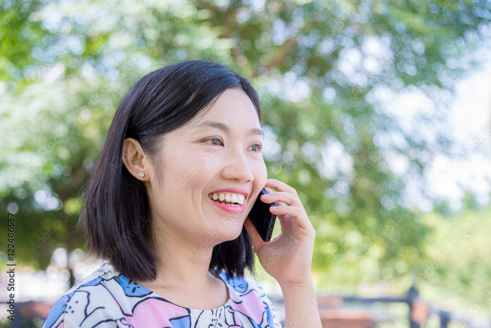 Beautiful asian woman talking with friend by smart phone Beautiful asian woman talking with friend by smart phone