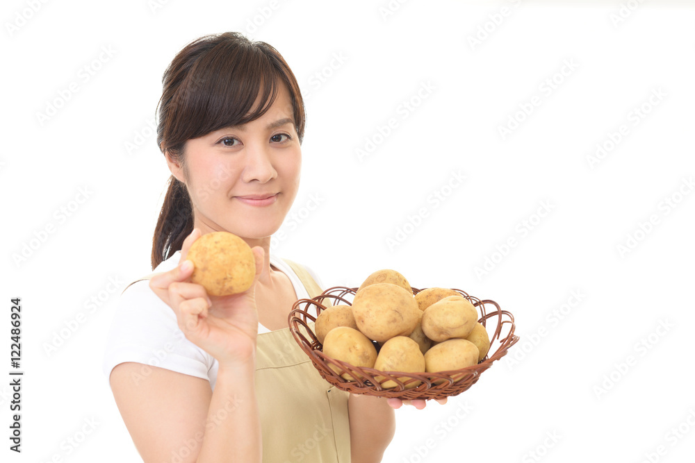 野菜を持つ笑顔の女性