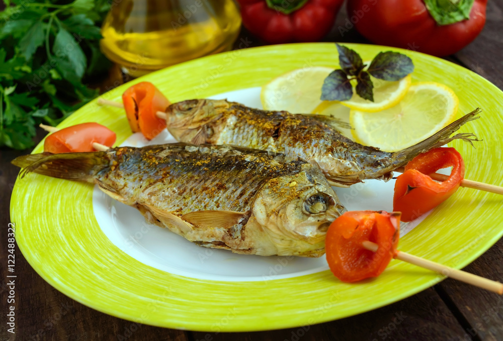 Fried fish (carp) on skewers with pieces pepper and lemon. Fried fish (carp) on skewers with pieces pepper and lemon.
