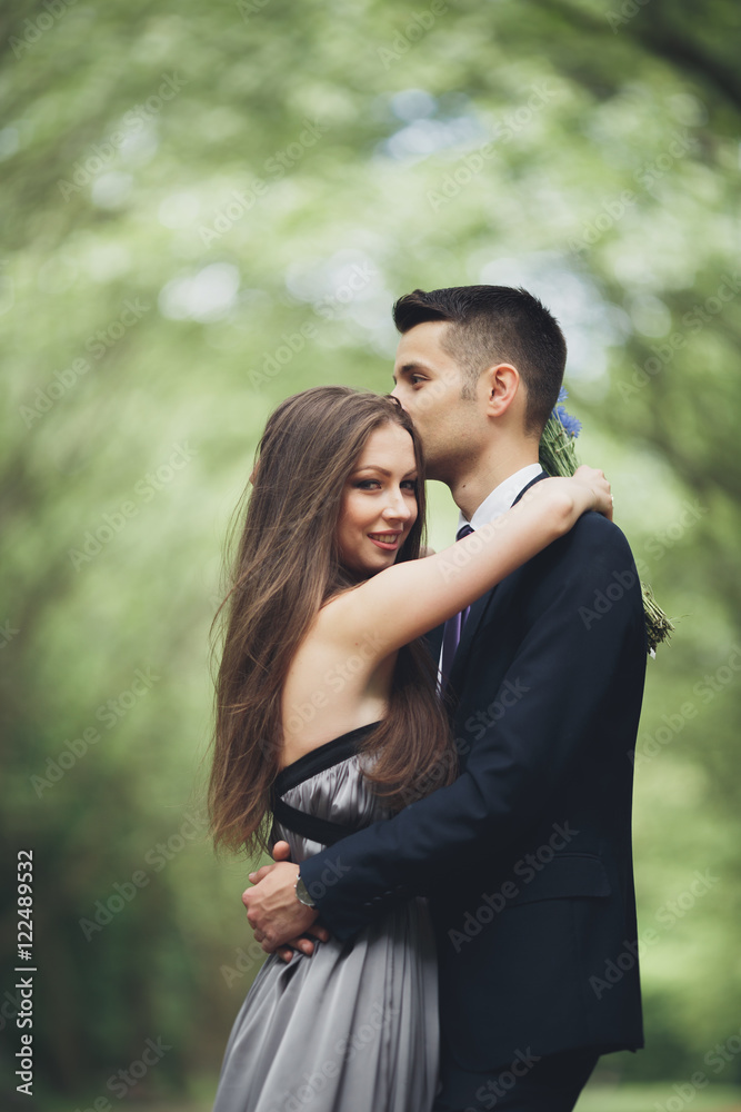 Fototapeta premium Young beautiful couple, girl with perfect dress posing in park