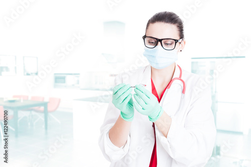 Young medical assistant preparing syringe for injection