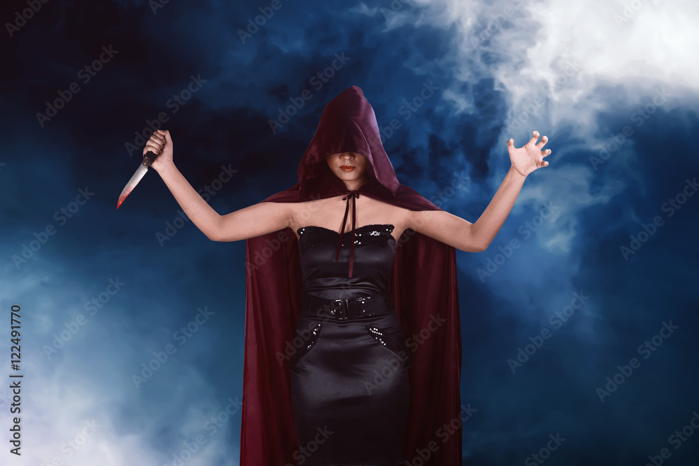 Murderer asian witch woman with red cloak holding bloody knife Murderer asian witch woman with red cloak holding bloody knife