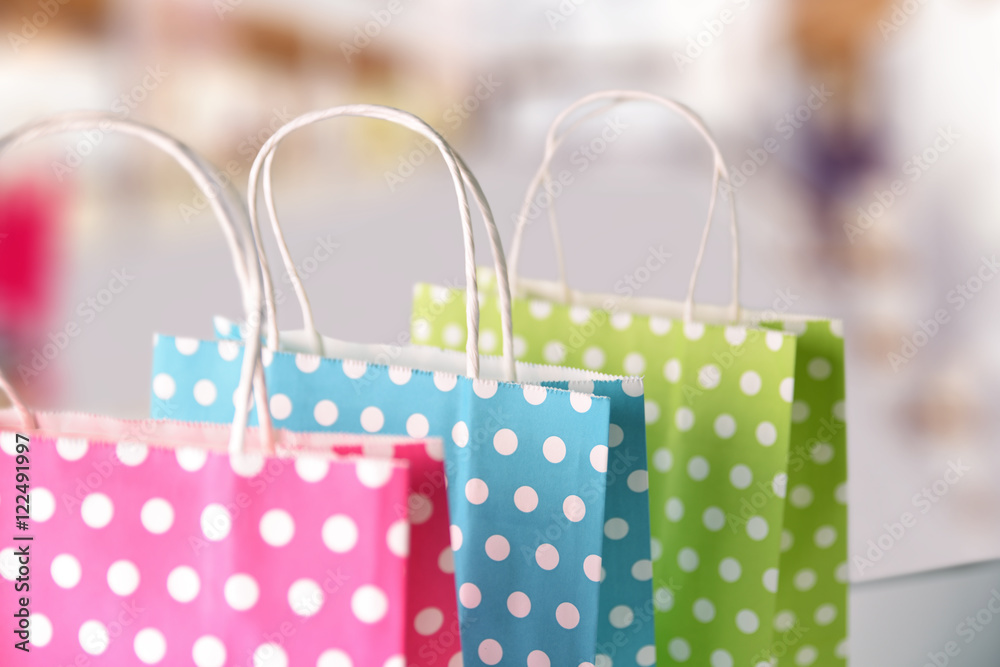 Three bags colored in a row on table in mall Three bags colored in a row on table in mall