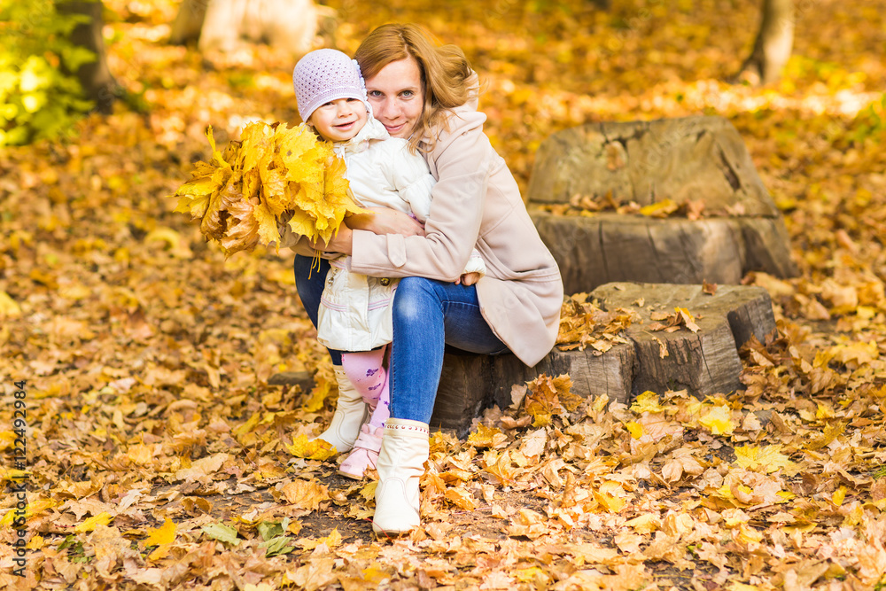 happy family: mother and child little daughter play, laughing cuddling on autumn walk in nature outdoors happy family: mother and child little daughter play, laughing cuddling on autumn walk in nature outdoors