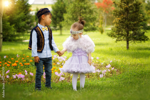 kazakh little boy and girl together playing in the summer park