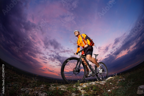 Fototapeta Naklejka Na Ścianę i Meble -  cyclist standing with mountain bike on trail at sunset