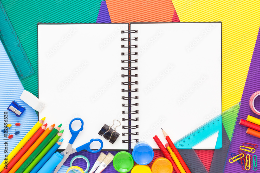 Colorful background with school supplies and open notebook. Colorful background with school supplies and open notebook.