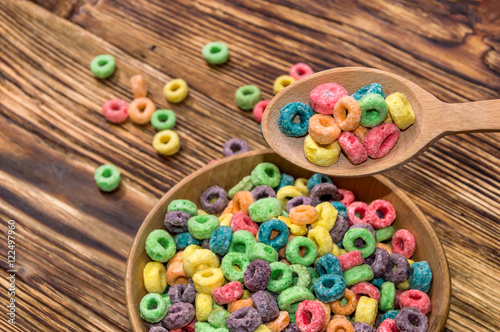 wooden spoon and wooden bowl with colorful cereal