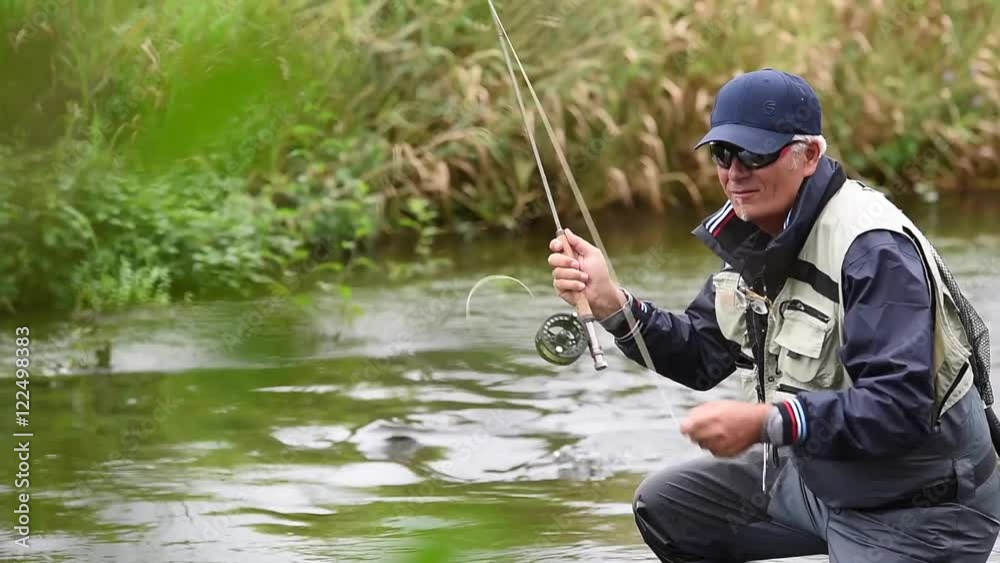Fly-fisherman fishing in river Fly-fisherman fishing in river