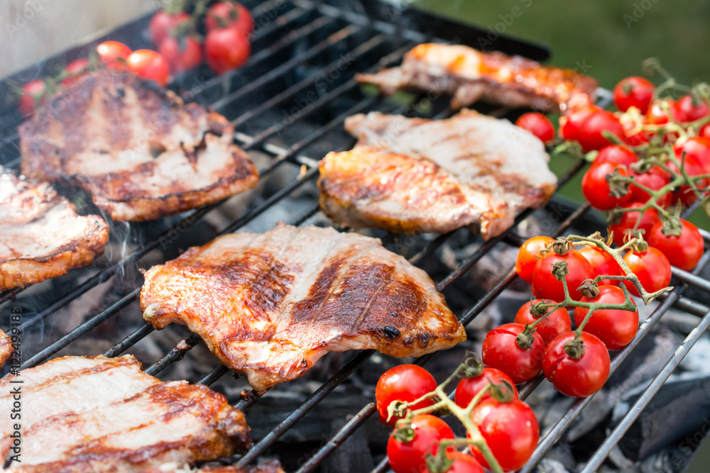 Delicious grilled meat with cherry tomatoes over the coals on a barbecue