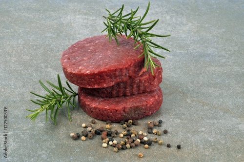 Steaks hachés crus avec brins de romarin et mélange de baies