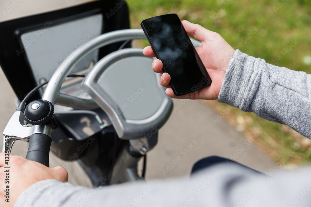 Guy sitting on bicycle and holding phone