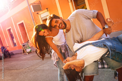 Group of happy young friends having fun on city street.Sunset.