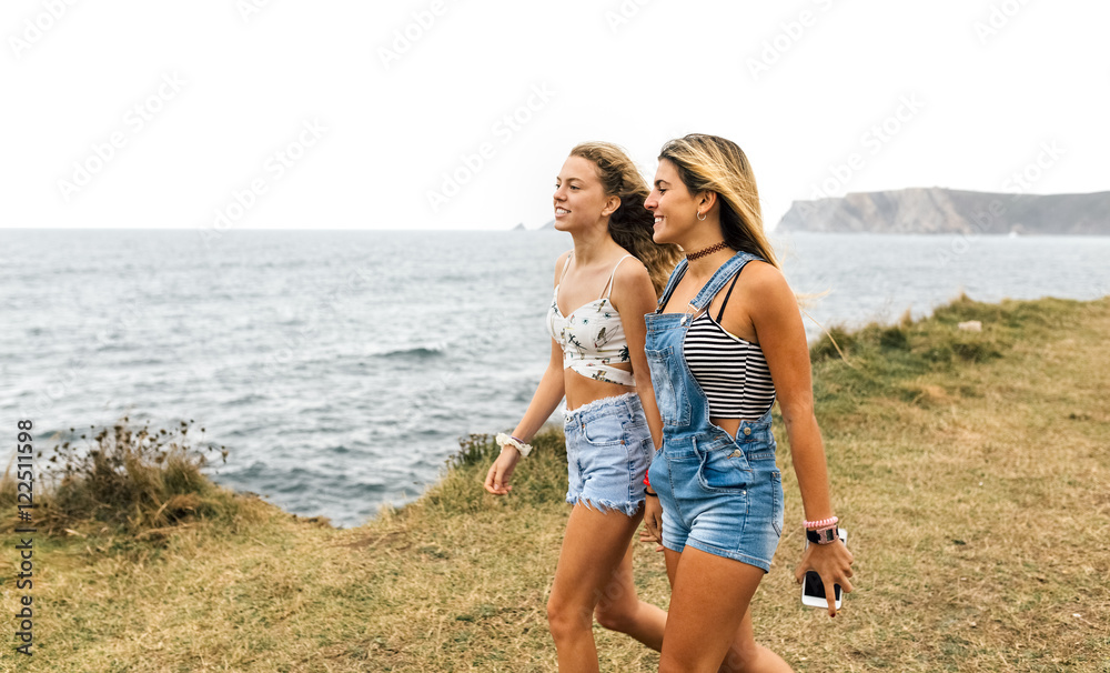 Two best friends strolling near the coast Two best friends strolling near the coast