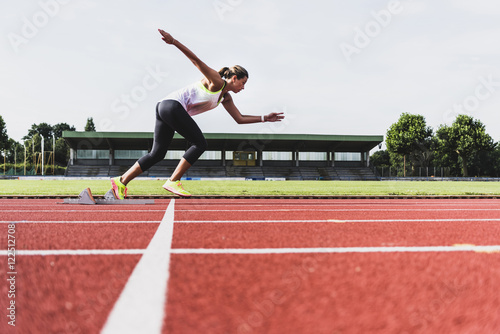 Young woman on tartan track starting