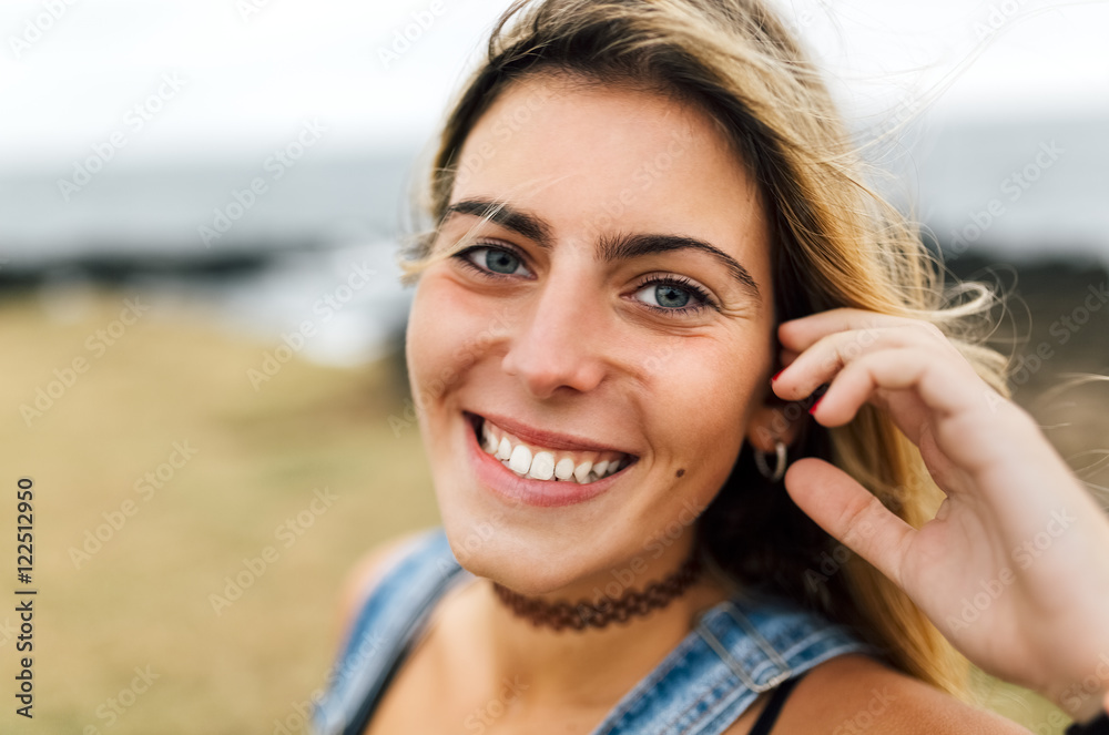 Portrait of smiling teenage girl sitting at the coast