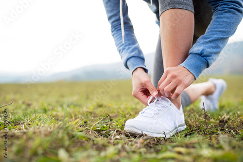 Close up of an unrecognizable young runner tying shoelaces