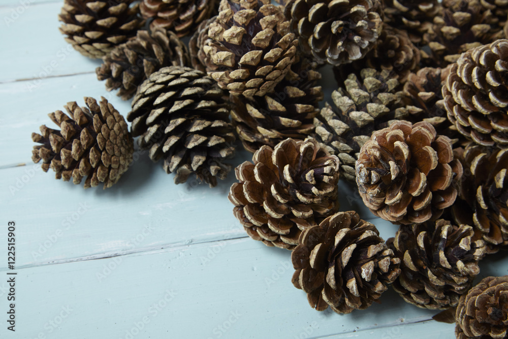 Pine cones arranged on a blue wooden background forming a page border Pine cones arranged on a blue wooden background forming a page border