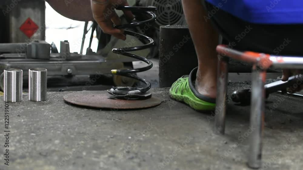 Repairman working for welding car coil spring (car suspension) by gas