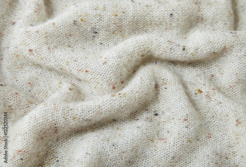 A full page of soft white knit background texture with flecks of color
