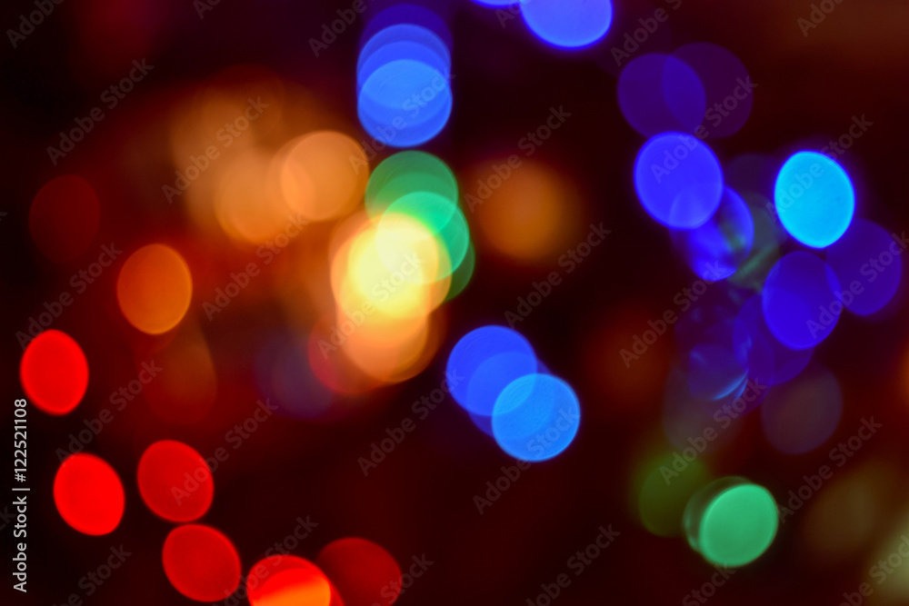 Christmas lights background. Blurred electric garland on Christmas tree. Red, green, yellow, orange, blue glow Christmas lights background. Blurred electric garland on Christmas tree. Red, green, yellow, orange, blue glow