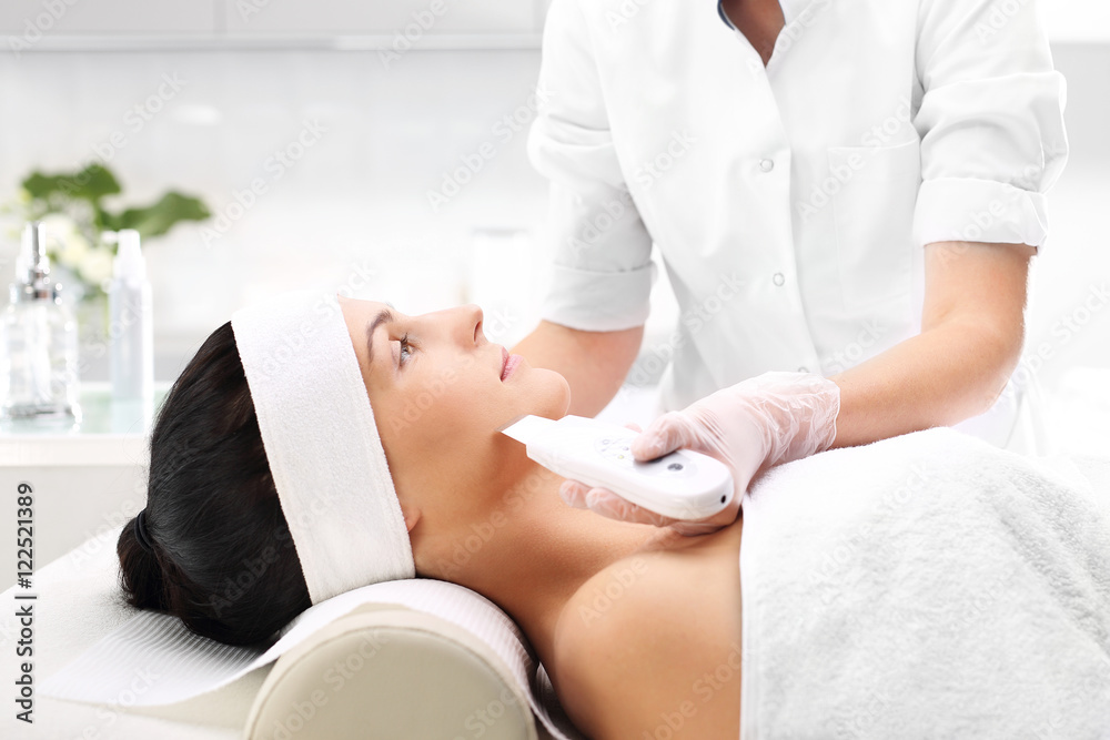 Obraz premium Zabieg na twarz, peeling, złuszczanie, odmładzanie, Twarz kobiety podczas zabiegu w salonie kosmetycznym