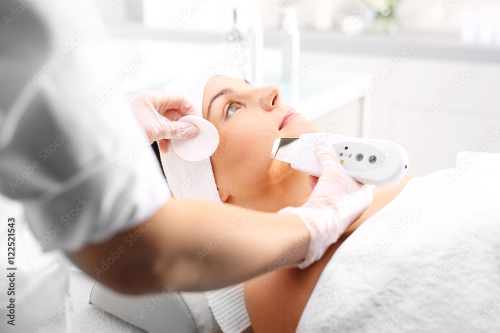 Obraz premium Peeling kawitacyjny , zabieg kosmetyczny na twarz. Twarz kobiety podczas zabiegu w salonie kosmetycznym